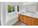 Bright bathroom featuring a double sink vanity, large window over a soaking tub, and ample counter space at 124 High Country Trl, Lafayette, CO 80026