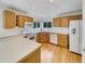 Bright kitchen featuring wood cabinets, white appliances, and a breakfast bar at 124 High Country Trl, Lafayette, CO 80026
