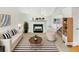 Bright, staged living room with a fireplace, striped rug, and comfortable seating creating an inviting atmosphere at 124 High Country Trl, Lafayette, CO 80026