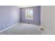 Cozy bedroom with soft lavender walls and neutral carpet has ample natural light at 3314 Astorbrook Cir, Highlands Ranch, CO 80126