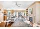 Open-concept living room with fireplace, seamlessly flowing into the kitchen area with bar seating at 3314 Astorbrook Cir, Highlands Ranch, CO 80126