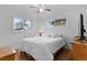 Bright bedroom with hardwood floors, a ceiling fan, and two windows providing ample natural light at 690 W 1St Ave, Broomfield, CO 80020