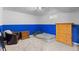 View of bedroom with blue accent wall, carpeted floors, chair, and a wooden dresser at 690 W 1St Ave, Broomfield, CO 80020