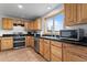 Well-equipped kitchen with wooden cabinets, stainless steel appliances, and black countertops at 690 W 1St Ave, Broomfield, CO 80020