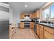 Functional kitchen featuring stainless steel appliances, wood cabinets, and tiled floors at 690 W 1St Ave, Broomfield, CO 80020
