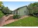 Backyard with wooden deck, green exterior, stone pathway, and lush landscaping at 2130 Chestnut Cir, Erie, CO 80516
