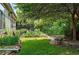 Lush backyard featuring flowers, stone path, and a bench under a mature shade tree at 2130 Chestnut Cir, Erie, CO 80516