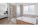 Bathroom featuring large tub, glass shower and bright natural light at 2130 Chestnut Cir, Erie, CO 80516