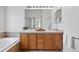 Bathroom with double sink vanity, soaking tub, and natural wood cabinets at 2130 Chestnut Cir, Erie, CO 80516