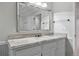 Bathroom with marble countertops, white cabinets, and a large mirror at 2130 Chestnut Cir, Erie, CO 80516