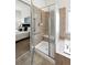 Accessible shower with glass doors, neutral tile, and safety bar, with view into the bedroom at 2130 Chestnut Cir, Erie, CO 80516