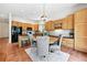 Open kitchen and dining area with black appliances and light wood cabinetry at 2130 Chestnut Cir, Erie, CO 80516