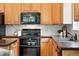 Kitchen close-up showcasing stainless steel appliances, tiled backsplash, and wood cabinets at 2130 Chestnut Cir, Erie, CO 80516