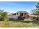 A view of the back exterior reveals an expansive backyard with a deck, ideal for gatherings at 1488 S Andes Way, Aurora, CO 80017