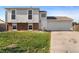 Split level home featuring a two-car garage, brick accents, and a well-maintained front yard at 1488 S Andes Way, Aurora, CO 80017