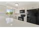 Bright and airy kitchen with white cabinetry, granite countertops, and modern black appliances at 1488 S Andes Way, Aurora, CO 80017