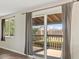 Open sliding glass doors reveal the backyard deck of this home, with large windows and bright light at 1488 S Andes Way, Aurora, CO 80017