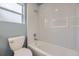 Light and bright bathroom with gray walls, white toilet and subway-tiled shower and bathtub at 1525 Roslyn St, Denver, CO 80220