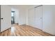This bright bedroom has light wood flooring, a closet with sliding doors, and a door to the bathroom at 1525 Roslyn St, Denver, CO 80220