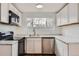 Modern kitchen features white cabinets, stainless steel appliances, and light countertops at 1525 Roslyn St, Denver, CO 80220