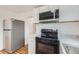 Modern kitchen with stainless steel appliances, new cabinets, and stone countertops at 1525 Roslyn St, Denver, CO 80220