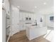 Open concept kitchen, white cabinets, large island at 8588 Eagle River St, Littleton, CO 80125