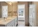 Bright bathroom featuring double sinks, glass shower, and bedroom access at 2426 Welton St, Denver, CO 80205