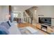 Sun-drenched living room features hardwood floors, a staircase, and stainless steel appliances in the distance at 2426 Welton St, Denver, CO 80205