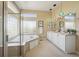 Bright bathroom featuring a soaking tub, glass shower, and double vanity with modern lighting at 5309 Mining Camp Trl, Parker, CO 80134