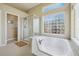 Bathroom featuring large soaking tub with glass block window and separate glass shower at 5309 Mining Camp Trl, Parker, CO 80134