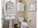 Powder room with pedestal sink and toilet with hardwood floors at 5309 Mining Camp Trl, Parker, CO 80134