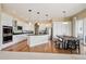 Bright kitchen featuring white cabinets, granite countertops, stainless steel appliances, and hardwood flooring at 5309 Mining Camp Trl, Parker, CO 80134