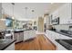 Open kitchen showcasing granite counters, stainless steel appliances, and hardwood floors with an open view to the living area at 5309 Mining Camp Trl, Parker, CO 80134