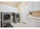 Laundry room featuring front loading washer/dryer and built-in cabinetry at 5309 Mining Camp Trl, Parker, CO 80134