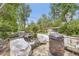 Landscaped backyard features a pool area with seating, a metal fire pit, and mature trees at 2220 Lee St, Lakewood, CO 80215