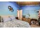 Bedroom featuring blue walls, wooden ceiling, vintage storage chest, and patterned bedding at 2220 Lee St, Lakewood, CO 80215