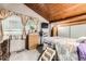 Comfortable bedroom featuring a window, wooden ceiling, dresser, and neutral tones for a serene atmosphere at 2220 Lee St, Lakewood, CO 80215