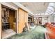 Spacious living room with green carpet, access to the outdoors, storage, and access to the kitchen at 2220 Lee St, Lakewood, CO 80215