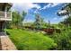 Spacious, well-maintained lawn with a wooden fence, garden and view of hill in distance at 14023 W Alaska Dr, Lakewood, CO 80228