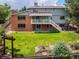 A spacious backyard featuring a well-maintained lawn, garden, and brick facade at 14023 W Alaska Dr, Lakewood, CO 80228
