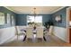 Formal dining room featuring blue walls, wainscoting, a chandelier, and natural light at 14023 W Alaska Dr, Lakewood, CO 80228