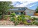 Charming home featuring a landscaped front yard with a mix of colorful flowers and stone accents at 14023 W Alaska Dr, Lakewood, CO 80228