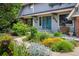 View of the front of the home with lush garden and walkway leading to front door at 14023 W Alaska Dr, Lakewood, CO 80228