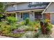 Close up of the front of the home with colorful flowerbeds at 14023 W Alaska Dr, Lakewood, CO 80228