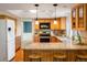 Well-lit kitchen features granite counters, stainless appliances, wood cabinets, and a breakfast bar at 14023 W Alaska Dr, Lakewood, CO 80228