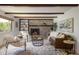 Comfortable living room displaying a brick fireplace, rustic wood beams, and modern furniture at 14023 W Alaska Dr, Lakewood, CO 80228