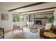 Inviting living room with brick fireplace, wood beams, and plenty of natural light at 14023 W Alaska Dr, Lakewood, CO 80228