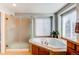 Bright bathroom with a glass shower, soaking tub, and a large window with natural light at 16590 Hitching Post Cir, Parker, CO 80134