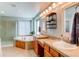 Luxurious bathroom featuring dual sinks, a soaking tub, a glass shower and stylish mirrors at 16590 Hitching Post Cir, Parker, CO 80134