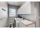 Functional laundry room with white cabinets, a utility sink, and modern washer and dryer at 16590 Hitching Post Cir, Parker, CO 80134